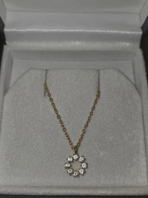 Guldhalsband med cirkelformad pärlberlock - Snyggt halsband i guld med en tunn kedja och en cirkelformad berlock dekorerad med små vita pärlor. Perfekt för dig som gillar stilrena och eleganta smycken med en touch av bling. 