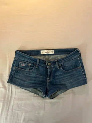 Blå denimshorts från Hollister - Snygga blå denimshorts från Hollister med låg midja. 
