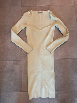 Ljus ribbad långklänning från Dilvin - Trendig ljusgrön långklänning från Dilvin med ribbad struktur och långärmad design. Klänningen har en snygg v-ringad urringning och är figurnära i modellen. Perfekt för dig som gillar stilrena och moderna plagg.