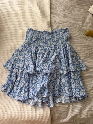 Mönstrad volangkjol - Säljer en blåmönstrad volangkjol i storlek S! Helt oanvänd! 