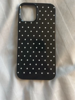 Svart mobilskal med vita prickar - Mobilskalet passar till iPhone 12.