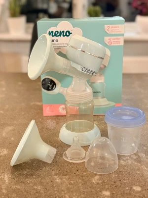 Elektrisk bröstpump Neno Uno - Elektrisk bröstpump från Neno, modell Uno. Pumpen är ljusgrön och vit med digital display och flera tillbehör som extra tratt, flaska, lock och napp, ingår även en liten burk där man kan spara mjölk i. Steriliserad och rengjord. 