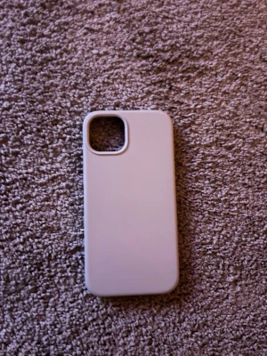 Grå silikonskal till iPhone - Snyggt ljuslila mobilskal i mjukt silikonmaterial som passar iPhone. Skalet har en slät yta och ett stort kamerahål i hörnet. Insidan är klädd med ett mjukt foder för extra skydd mot repor. Perfekt för dig som vill ha ett stilrent och enkelt skal.