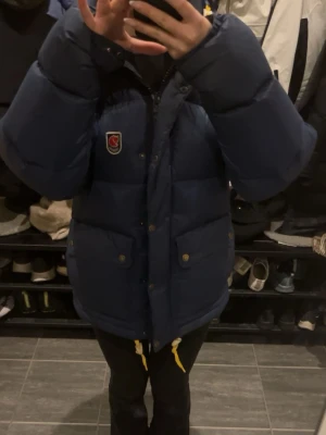 Mörkblå dunjacka från Fjällräven - Köpt för två vintrar sedan. Fint skick, inga fläckar eller hål. Kommer inte sänka priset när en ny kostar 7400kr på Fjällrävens hemsida.💕 skriv gärna ifall ni har några frågor😊
