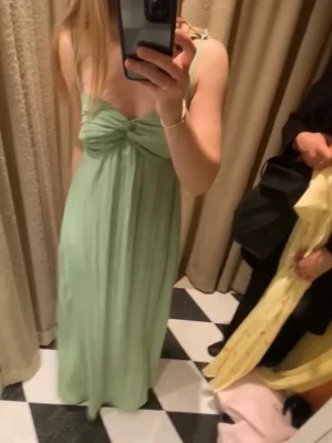 SLUTSÅLD Ljusgrön adoore långklänning  - Säljer denna Såå fina ljusgröna långklänning med smala axelband och snygg knyt-detalj framtill. Klänningen har en flowy passform och är perfekt för sommarens alla tillfällen. Materialet känns lätt och luftigt och klänningen är bara använd 2 gånger. Storlek 32 men sitter som en 34/36 på mig som vanligtvis brukar ligga därimellan.        OBS bild 3 är lånad 💘
