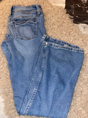 Gina Tricot jeans strl 158 - Gina Tricot jeans strl 158  Snygga blå jeans från Gina Tricot i storlek 158 med dubbla knappar framtill.  Använda och välälskade men fortfarande användbara 💙  Skick: • Slitage mellan benen • Lagning baktill (se bild där jag pekar) • Nötta längst ner vid bensluten • I övrigt hela och fungerar fint men välanvänd  Perfekta som slit och släng jeans, till skolan eller som extra byxor.  Där av det billiga priset. Testar att sälja innan det slängs.
