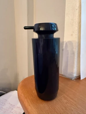 Svart tvålpump i plast - Säljer en stilren svarta tvålpump i plast med cylinderformad kropp och rundad topp. Perfekt för att ha i köket eller badrummet samt enkel att använda tack vare tryckknappen på locket. 