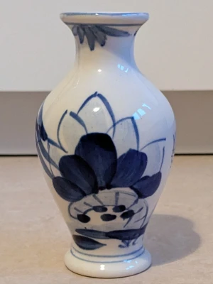 Vas - En liten vit och blå vas med ett blommönster. Vasen är mycket bra skick 