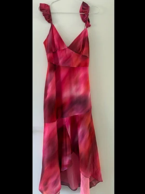 Rosa klänning med volang - Säljer denna supersöta klänning i rosa toner från Showpo. Perfekt för bal eller andra uppklädda event men också som en fin sommarklänning. Klänningen är helt oanvänd med lappen kvar. 