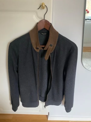 Mörkgrå cardigan från Massimo Dutti - Snygg mörkgrå cardigan från Massimo Dutti med hel dragkedja och klassisk krage. Tröjan är i mjukt material och har en clean look utan mönster. Perfekt för lager-på-lager och funkar till många olika stilar. Sjukt fin kvalite wool blend. Nypris: 1699Kr🔥