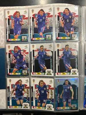 Samling Panini fotbollskort EM 2012 - Säljer en samling Panini fotbollskort från EM 2012 med spelare från Kroatien, Grekland och Nederländerna bland annat. Korten har färgstarka motiv, spelarstatistik och landslagsdräkter i blått, vitt och rött. Perfekt för dig som gillar att samla på fotbollskort och vill ha en komplett pärm. Priset är inte spikat, kom med bud. Högst bud så är dom dina! Endast seriösa bud.