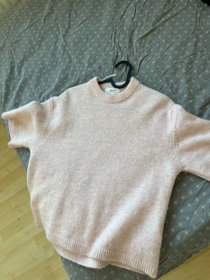 Ljusrosa stickad tröja  - Ljusrosa stickad tröja från Gina tricot med rund halsringning och mjukt tyg. Tröjan har en boxy passform och är gjord i ett mjukt material som känns riktigt cozy. Perfekt för dig som gillar en enkel och clean look.