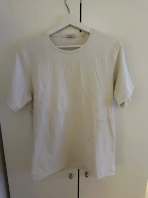 Vit basic t-shirt | Bläck - En enkel vit t-shirt från Bläck med rund hals och korta ärmar. Tillverkad i mjuk bomull som känns skön mot huden. Perfekt att matcha med jeans eller shorts för en clean och stilren look.