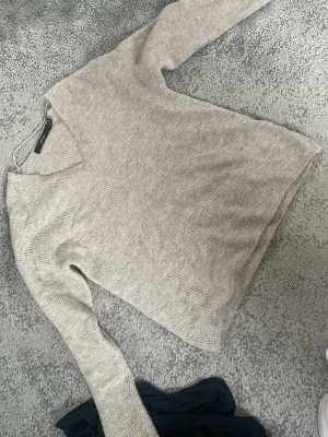Beige stickad tröja Vero Moda - Säljer en beige stickad tröja från Vero Moda med v-ringning och ribbad struktur. Tröjan har långa ärmar och är gjord i mjukt material som passar perfekt för alla dagar. Enkel och stilren design som är lätt att matcha med olika outfits. Väldigt fint skick men har använts🥰