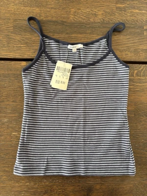 Subdued NY Randig blå och vit linnetopp - Säljer en randig linnetopp från Subdued i blått och vitt. Toppen har smala axelband och är tillverkad i mjuk bomull, perfekt för varma dagar. Enkel och stilren design som passar till det mesta. Storlek M men passar mer som en S
