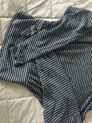 Randiga leggings från Bershka - Supersnygg tröja från Bershka i svart och grått med tunna horisontella ränder. Tillverkade i ett mjukt och stretchigt material som sitter tajt och följer kroppen. Perfekta för dig som gillar en enkel men snygg stil.