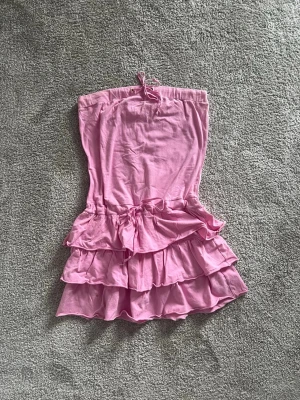 Rosa volangklänning  - Söt rosa volang klänning! Fin nu till sommaren. Finns två små fläckar, som går bort i tvätten 😊💗