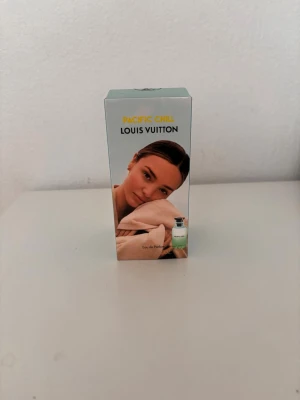 Louis Vuitton Pacific Chill parfym - Louis Vuitton Pacific Chill Eau de Parfum i en stilren, ljusblå kartong med motiv av natur och en person. Flaskan syns på framsidan och har en elegant, minimalistisk design. Parfymen utstrålar exklusivitet och modern känsla.
