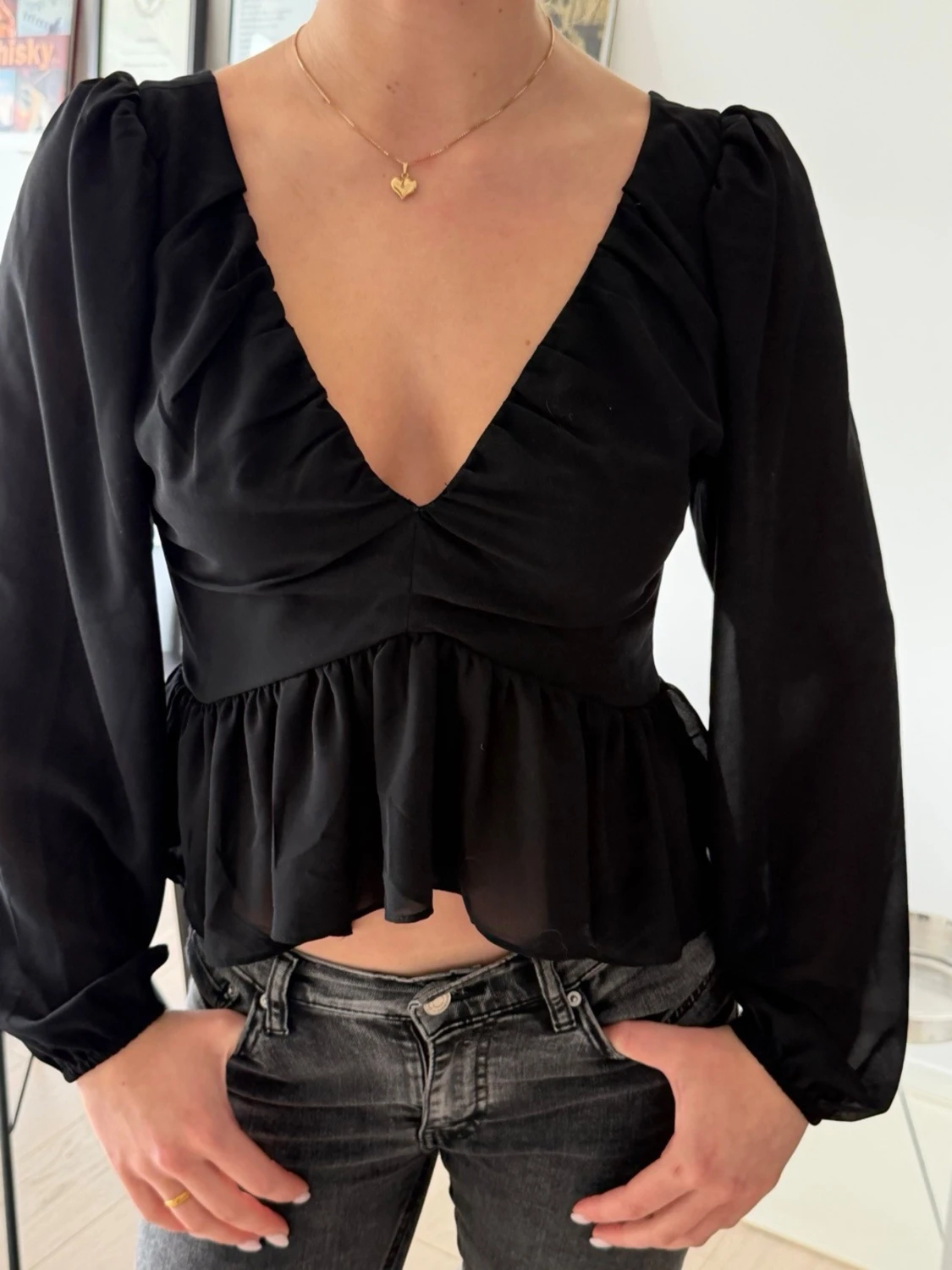 Svart v-ringad blus med volang