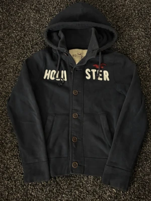 Hollister cardigan - sjukt eftertraktad! - 🔥 Extremt eftertraktad Hollister-hoodie, stl M, skick 8/10 🔥 Black Week-REA! Passa på medan priset är sänkt – det här är en av Hollisters mest populära modeller och den dyker nästan aldrig upp. Sitter perfekt, sjukt snygg och funkar till ALLT.  Den här kommer försvinna direkt – folk brukar köpa såna här på sekunder. Först till kvarn. Köp nu innan någon annan hinner före!  Ta liknande som den