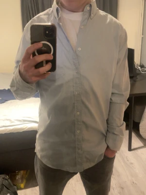 Ljusblå Oxfordskjorta från Gant - Säljer denna snygga Oxfordskjorta från Gant, då jag inte använder den längre. Skjortan är i en snygg ljusblå färg som passar perfekt till sommaren, skjortan har en snygg ficka på bröstet med gant loggan på. Har du frågor är det bara att höra av sig! 