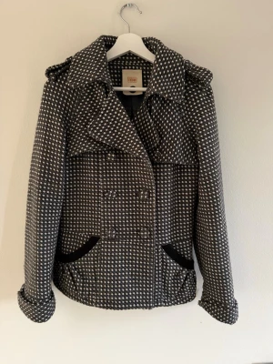 Mönstrad kappa från Object - Snygg kappa från Object i svartvitt rutmönster med dubbelknäppning och bred krage. Storlek S men passar både xs och m. Bra skick då den inte kommit till användning.