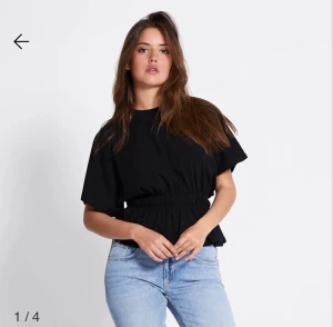 Svart topp med resår i midjan - Trendig svart topp med korta ärmar och resår i midjan, storlek M, ny utan prislapp 