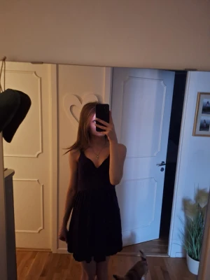 Svart kort klänning med v-ringning - Säljer en svart kort lila klänning med v-ringning. Klänningen har en enkel men fin design som passar perfekt till sommaren eller fester. Materialet känns mjukt och lätt. 