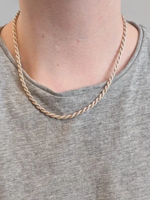 Tjockt tvinnat halsband/ äkta silver (925-stämplat) - Säljer ett stilrent halsband med tvinnad kedja i silver. Halsbandet har en klassisk design med rundad form. 42-43 cm full längd och 21-22 cm stängd, perfekt för att ge en clean och modern vibe till din outfit. Passar dig som gillar klassiska smycken med lite extra edge. Låset är robust och märkt med 925-stämpel.