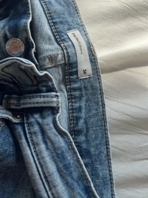 Ljusblå raka jeans från perfect jeans - Säljer ett par ljusblå jeans från perfect jeans i storlek 36. Jeansen har klassisk femficksmodell, raka ben och normal midja. Tillverkade i ett mjukt denimtyg med snygg tvätt och silverfärgade detaljer. Perfekta till din vardagsstil!