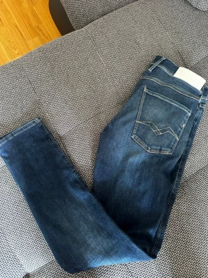 Mörkblå anbass hyperflex från Replay - Snygga mörkblå skinny jeans från Replay med klassiska kontrastsömmar och bakfickor med dekorativ söm. Jeansen har en smal passform och är tillverkade i stretchigt denimtyg för extra komfort. Perfekta till en avslappnad stil.