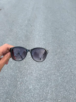 Svarta solglasögon med bred båge - Snygga svarta solglasögon med bred båge och mörka glas. Klassisk form som ger en cool vibe och passar till de flesta outfits. Tillverkade i syntetmaterial och perfekta för soliga dagar.