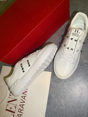💕 Valentino Garavani 38 Rockstud Öppen Open Shoe Skor Vit Silver - Hej!!! Jag säljer dessa Valentino Öppna skor i vit färg och silver nitar 💕✨️ Helt oanvända och bara prövade, 100% skick. Skor vit låda och påse följer med i fullpris. Vi kan diskutera priset och prata mer. Skriv till mig så kan du få nya skor för sommaren och hösten 😊💜 MVH