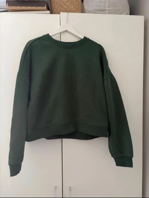 Mörkgrön sweatshirt från ONLY SWEAT LAB - En enkel och stilren mörkgrön sweatshirt från ONLY SWEAT LAB. Tröjan har rund halsringning, ribbade muddar vid ärmslut och nederkant samt en avslappnad passform. 