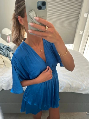 Blå Zara klänning i satin - Blå klänning i satin från Zara, har inbyggda shorts under men de ser ut som en klänning både fram o bak. Härlig på sommaren då den är tunn. Bra skick! Är storlek XS men funkar på S med.