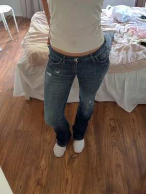 Blå bootcut jeans med slitningar - Säljer att par mörkblåa lågmindjde jenas. Super sköna och har ett stretchigt material. 