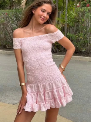 Ljusrosa offshoulder volangklänning - Supersöt ljusrosa kortklänning med offshoulder och volangkant. Klänningen har smockad överdel och är tillverkad i ett lätt, luftigt material som passar perfekt till varma dagar. Romantisk och feminin look med kort ärm och figurnära passform.