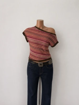 Randig offshoulder topp i rosa toner - Säljer en unik offshoulder topp med kort ärm och randigt mönster i rosa, orange, brun och beige. Toppen har en luftig, stickad struktur och är croppad med mörkbruna kanter. Perfekt för dig som vill sticka ut med färg och cool design.