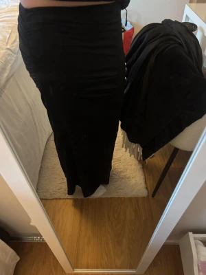 Svart långkjol med scrunch på sidan  - Säljer en svart långkjol med tight passform. Super snygg till en söt sommartopp. 