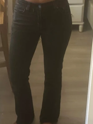 Svarta Levis bootcut jeans  - Snygga svarta bootcut jeans, från Levis. Storlekslappen är bortklippt, men passform 32-36. Förg grå / svart