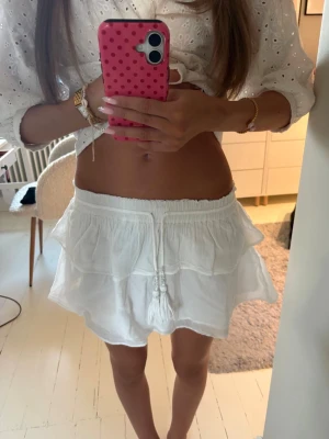 Vit volangkjol med snörning - Söt vit linne kortkjol med volanger och snörning i midjan. Elastisk midja så den passar flera olika midjemått.💞Jag bär vanligtvis xs/s och den passar mig!