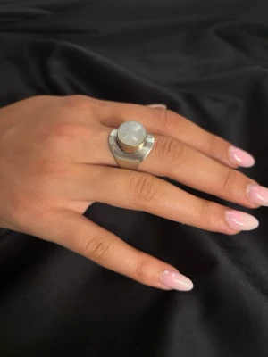 Silverring 925 med stor sten - Unik silverfärgad ring med bred band och en stor, rund sten på toppen. Aldrig använd och i väldigt fint skick.