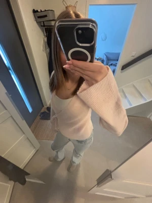 Ljusrosa stickad kofta Gina Tricot - Säljer en superfin ljusrosa stickad kofta från Gina Tricot. Koftan har en omlottmodell med knytband i midjan och långa ärmar. Perfekt att slänga över ett linne eller t-shirt för en chill och snygg look.