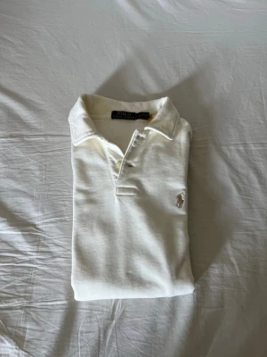 Ralph lauren kräm färg shirt  - Snygg Ralph Lauren-tröja i krämvit färg. Klassisk modell med broderad logga på bröstet och halv dragkedja. Tröjan är i mycket gott skick, sparsamt använd och utan hål eller fläckar. Perfekt för både vardag och en mer uppklädd stil. Storlek S. Hör gärna av dig om du har frågor eller vill se fler bilder. Äkta 