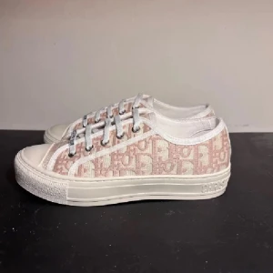 Dior Oblique låga sneakers - (KVITTO FINNS!!!)Snygga låga sneakers från Dior med det klassiska rosa och vita Oblique-mönstret. Skorna har vita snören med Christian Dior-detaljer, vit gummisula och tåparti i vitt. Tillverkade i canvas och gummi för en trendig och exklusiv look.