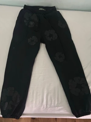 Denim Tears Cotton Wreath Black  - Säljer de efterlängtade Denim Tears Cotton Wreath Black Pants, pågrund av att jag inte kan ha på mig dem längre. Perfekt för dig som letar moderna streetwear kläder. Har inte kvitto eller köpebevis därför säljer jag byxorna för mycket mindre än vad dem egentligen är värda. Inga defekter eller nånting som stör när du använder dem.  Ge gärna ett prisförslag 🤝 MVH Rasmus.