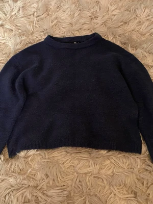 Mörkblå stickad tröja  - En enkel och stilren mörkblå stickad tröja från lager 157. Tröjan har rund halsringning, långa ärmar och ribbade muddar vid ärmslut och nederkant. Perfekt för lager på lager och passar till det mesta i garderoben.