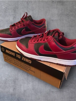 Nike Dunk Low  - Nike dunk Low Next Nature. Röd, svart och vit färg. Helt nya, aldrig använda. Inga defekter. Originalbox följer med. Storlek 44,5. Skicka gärna prisförslag, postar alltid inom 24h!