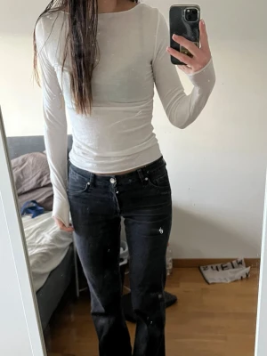 Soft vit långärmad topp - Vit långärmad topp med rund halsringning. Toppen har en tight passform och är tillverkad i ett mjukt, stretchigt material som sitter snyggt på kroppen. 