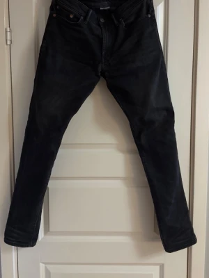 Svarta slim fit jeans - Säljer ett par svarta slimfit jeans från American Eagle. Jeansen har en något tvättad look och en passform som sitter snyggt längs benen.